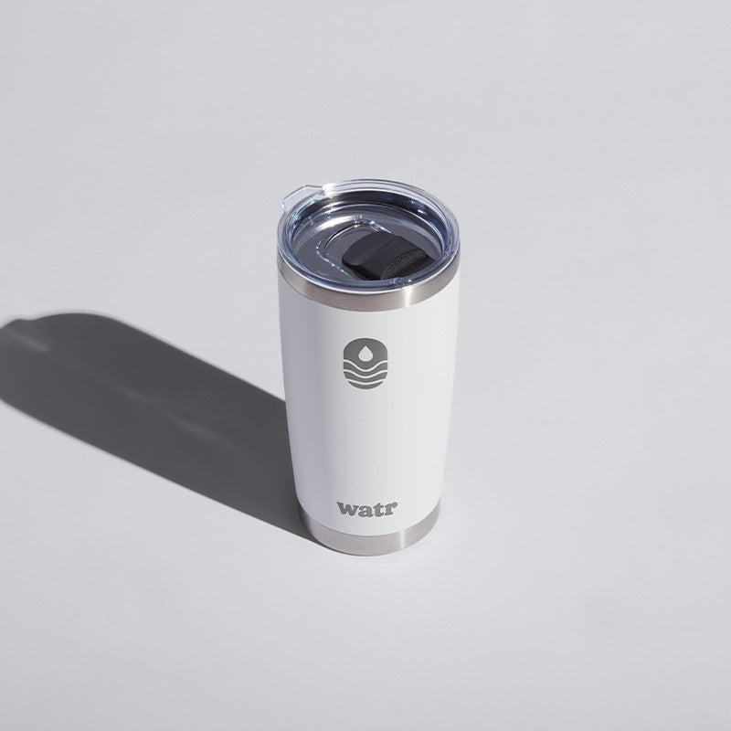 White 20 oz WATR Tumbler with a transparent lid, featuring a minimalist logo design, displayed on a light background with a distinct shadow.