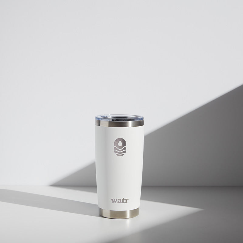 20 oz WATR branded tumbler in a modern setting, featuring a sleek white and stainless steel design with logo, positioned against a minimalist background with shadows.
