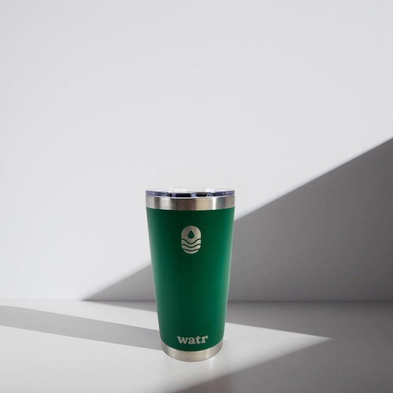 Green tumbler with silver lid on a white background