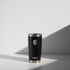 Alt text: "A 20 oz WATR Tumbler in black with a silver rim and clear lid, featuring a white minimalist wave logo above the brand name &
