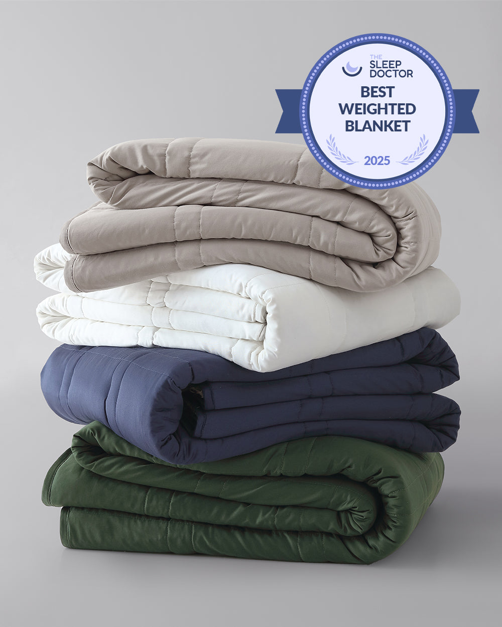 A stack of folded weighted blankets in the colors pebble white, silver sage, and luna blue. [42934587621595, 45574417809627, 42934587818203, 45574417940699, 42934587883739, 46452819001563, 43690188472539, 42934587850971, 46452818444507]