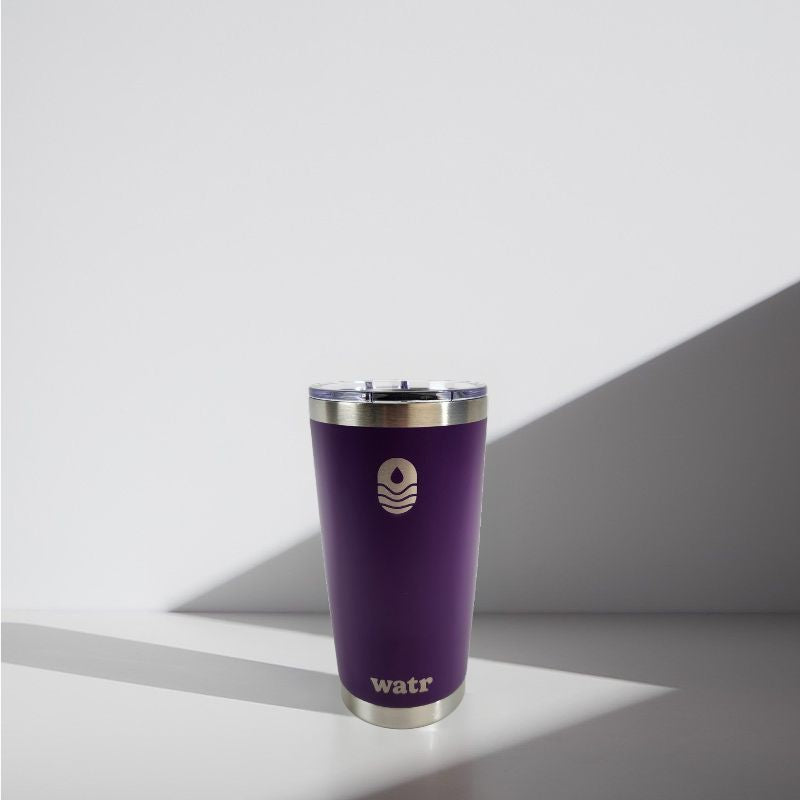 Purple tumbler with silver lid on a light gray background
