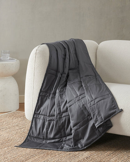 midnight weighted blanket draped over the arm of an ivory sofa  [47867971993819, 47867972157659, 47867972255963, 47867972354267, 47868867870939, 47868894675163, 47868894707931, 47868894740699, 47868894773467, 47868895658203, 47868895690971, 47868895723739]